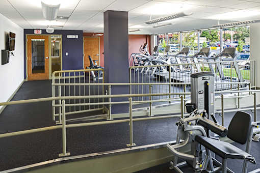 a gym with weights and cardio equipment in a building