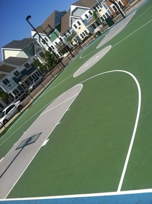a basketball court in front of a row of houses