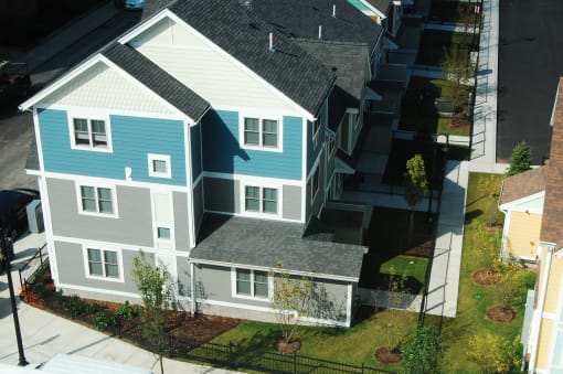 a house with a gray roof and a blue house with white and gray siding