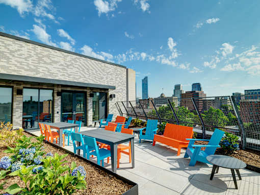 A patio with blue and orange chairs and tables.