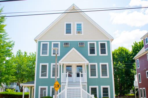 a blue house with a yellow street sign in front of it