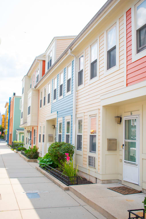 a row of townhomes with a sidewalk in front of them