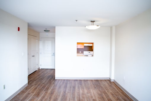 a bedroom with white walls and hardwood floors