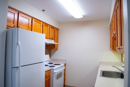 a kitchen with white appliances and wooden cabinets