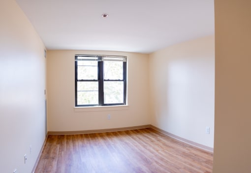 an empty room with white walls and a window