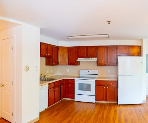a kitchen with wooden cabinets and white appliances