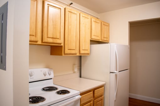 a kitchen with white appliances and wooden cabinets and a refrigerator
