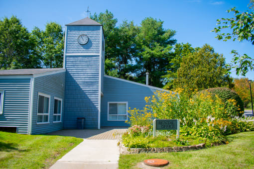 a blue building with a clock tower and a sign in front of it