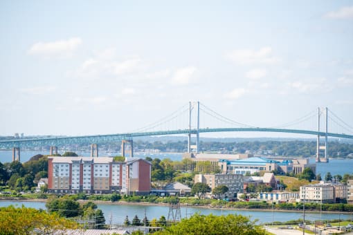 a view of the bridge over the water and a city with buildings and a river