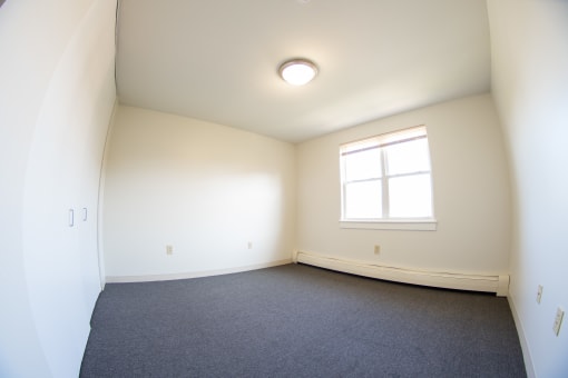 an empty room with white walls and a window