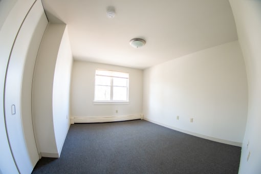 an empty room with white walls and a window