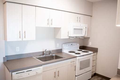 A kitchen with white cabinets and appliances.
