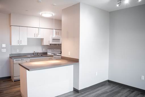 A kitchen with white cabinets and a white island.