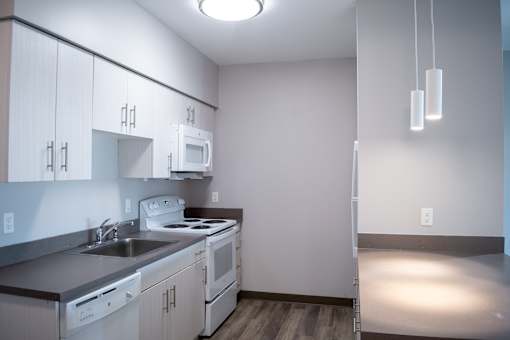 A kitchen with white cabinets and appliances.