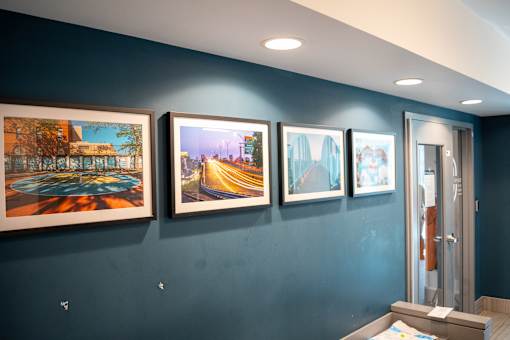 Four paintings are hanging on a wall.