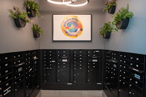 A wall of mailboxes with a colorful painting hanging above them.