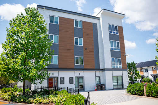 A modern apartment building with a white, brown, and grey exterior.