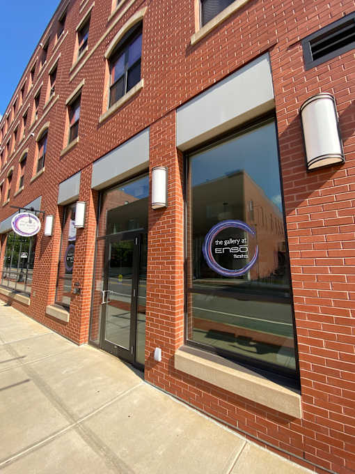 A building with a brick facade and a large window reflecting the sky.