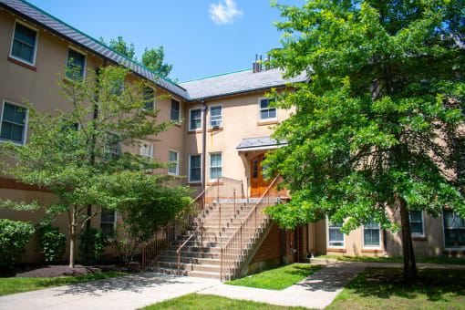 a building with stairs and trees in front of it