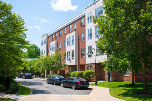 a brick and white apartment building with cars parked in front of it
