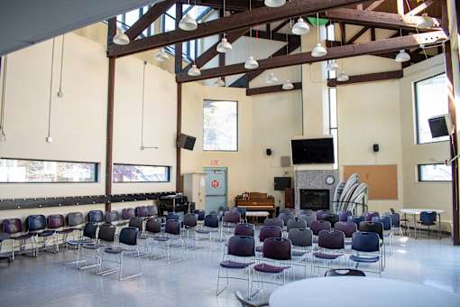 a large room with tables and chairs and a fireplace