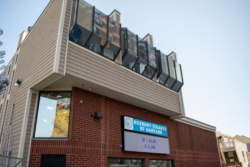 the front of a brick building with a sign for the county office of patient services
