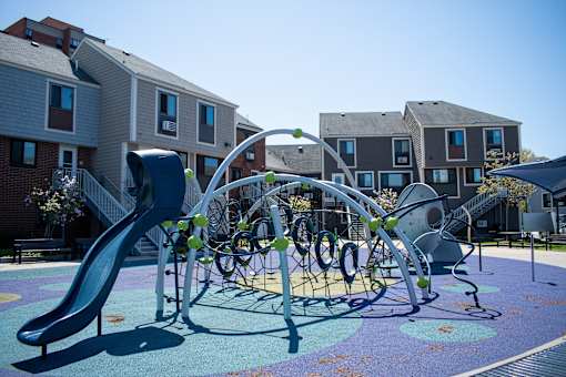 a playground at an apartment complex with a slide