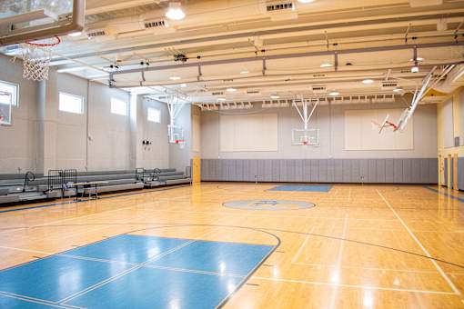 a gymnasium with a basketball court and a blue gym floor