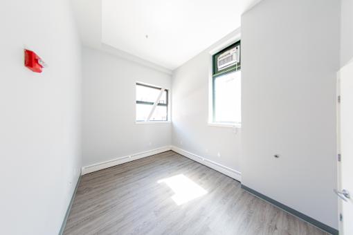 A room with a wooden floor and a window.