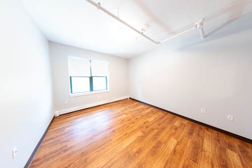 Empty room with wooden floor and white walls.