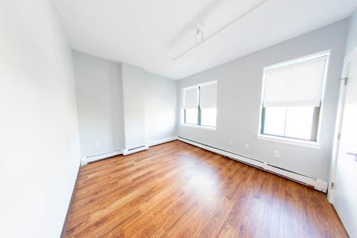 Empty room with wooden floors and white walls.