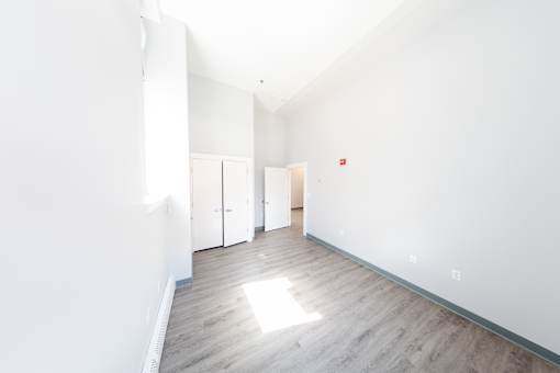 A long hallway with wood floors and white walls.