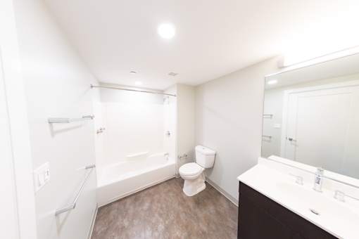 A white toilet sits in a bathroom next to a sink.