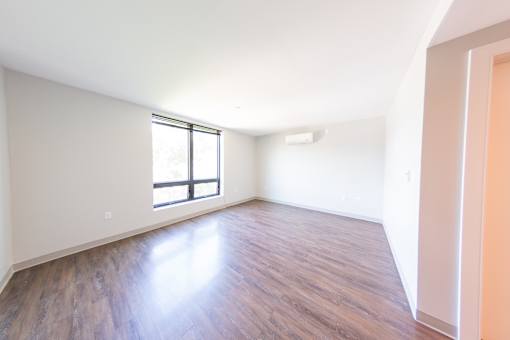 A room with wooden flooring and a window.