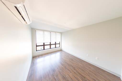 A room with a window and a wall-mounted air conditioner.