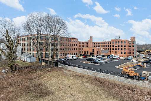 A large red brick building with a parking lot in front.
