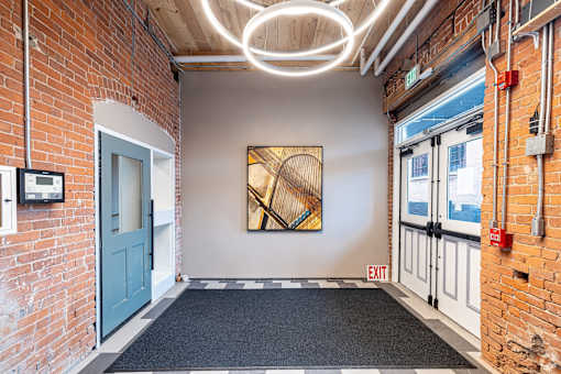 A hallway with a blue door and a painting on the wall.