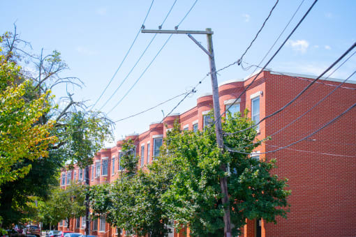 a row of red brick buildings with trees in front of them