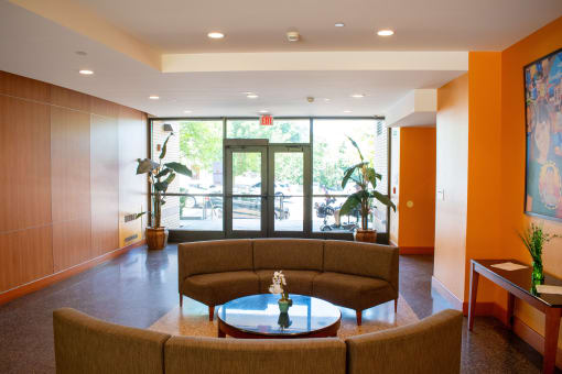 a living room with orange walls and a brown couch