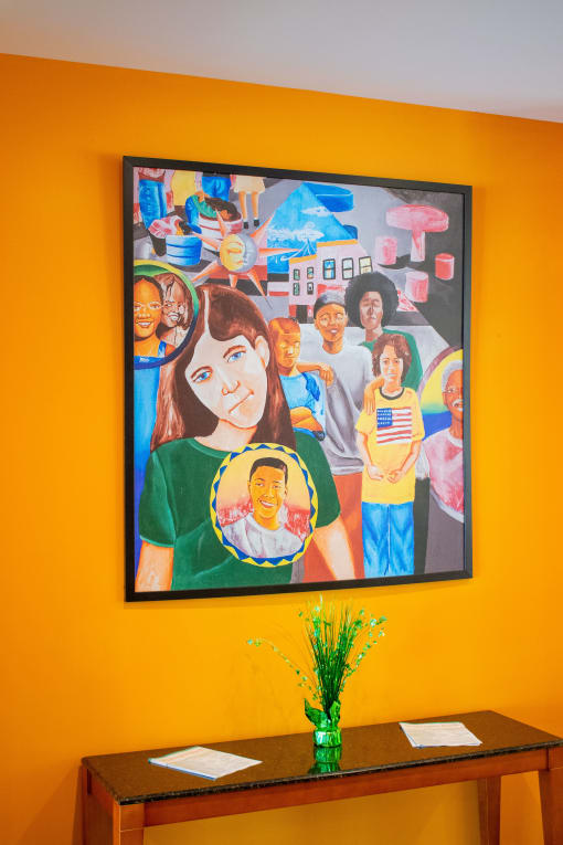 a painting of a group of children on an orange wall
