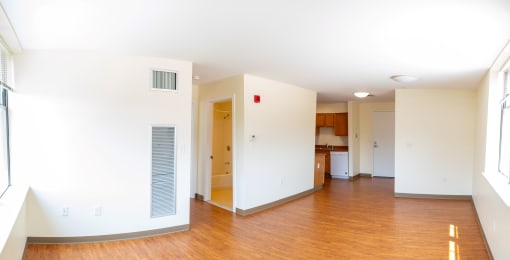 an empty living room with white walls and hardwood floors