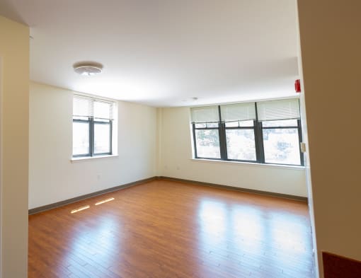 a bedroom with hardwood floors and a large window
