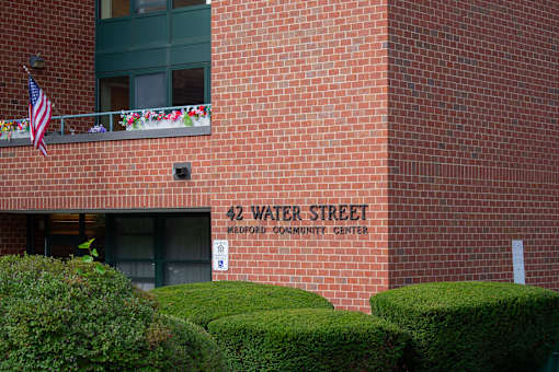 A brick building with a balcony and a sign that says 42 Water Street.