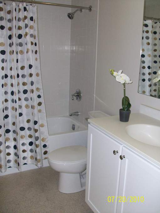 A white toilet sits in a bathroom next to a sink.