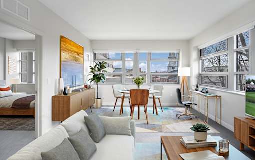 a living room with a white couch and a table and a window