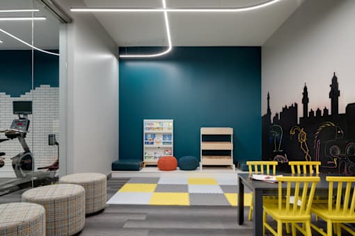 a room with a table and chairs and a blue wall with a map on it