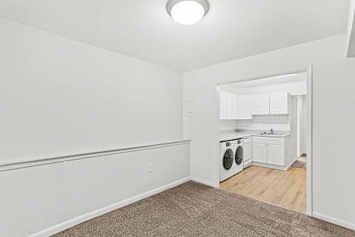 living room and kitchen with in unit laundry machines