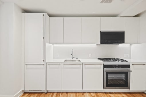 a kitchen with white cabinets and a stove and a sink