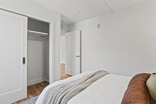 A bedroom with a bed and a closet.