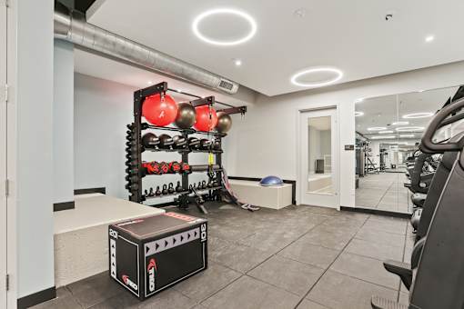 A gym with a weight rack, a bench, and a weight stack.